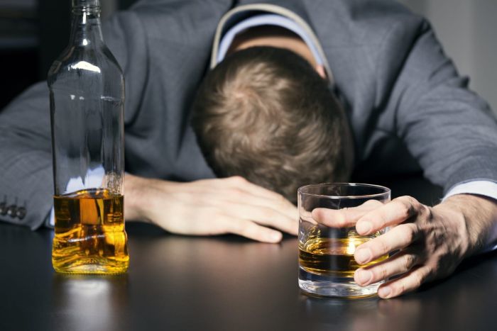 Drunk businessman holding a glass of whiskey